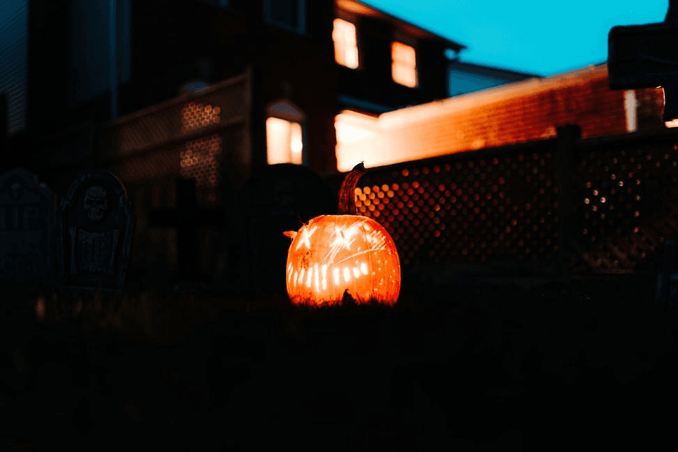 Glowing carved pumpkin outside a house